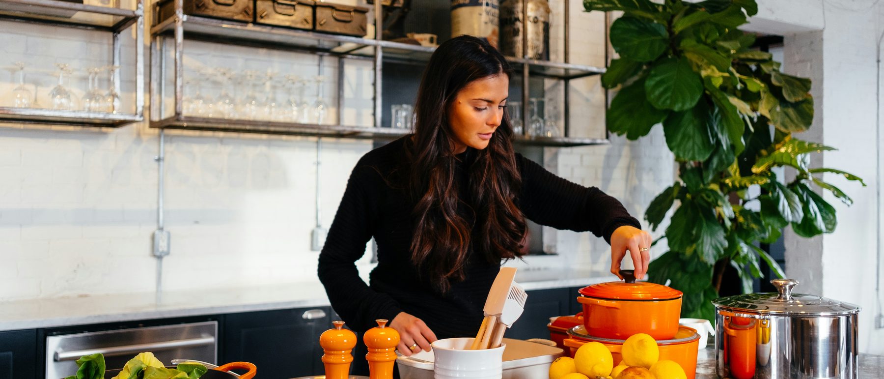 Cooking dinner at home with fresh greens, lemons, and a pot ready on the counter